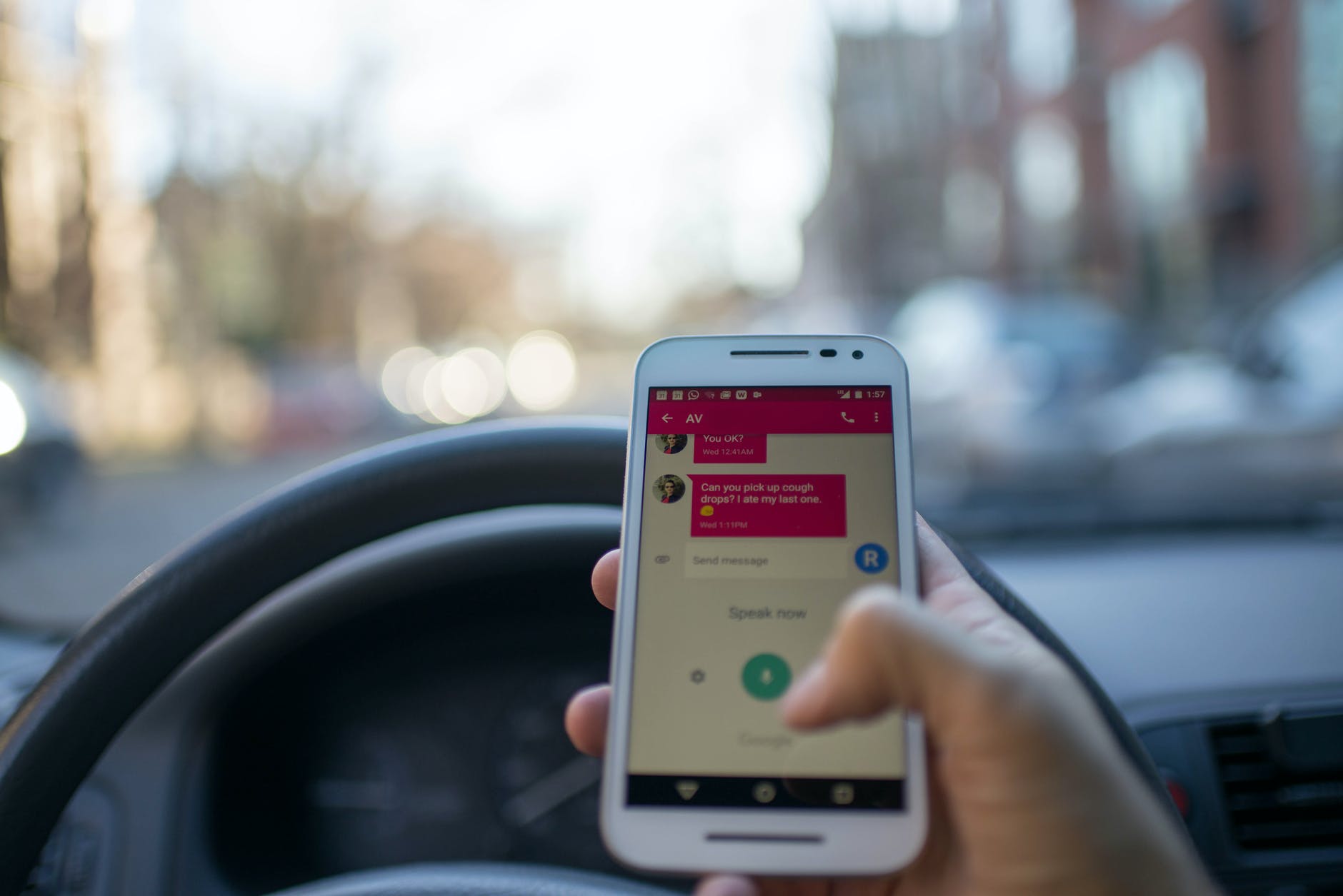 person holding white smartphone inside vehicle