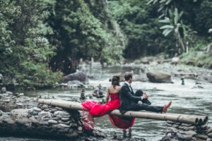 man and woman sitting on bamboos