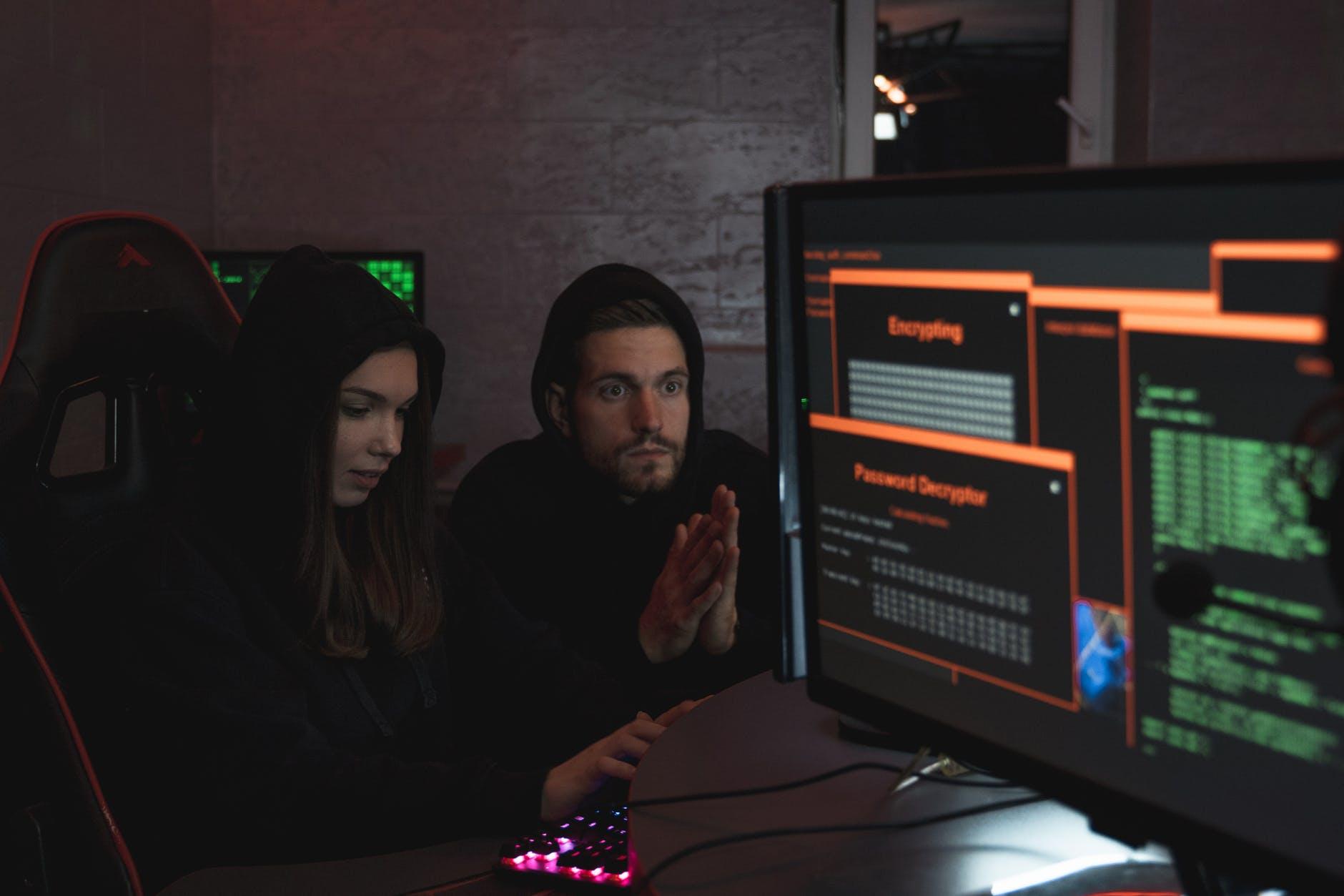 man and woman hacking a computer system