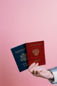 person holding blue and red passports