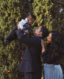 man in black suit carrying his son