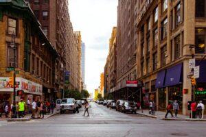 people walking on alley surrounded by high rise buildings