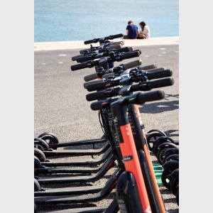 black kick scooters parked near body of water