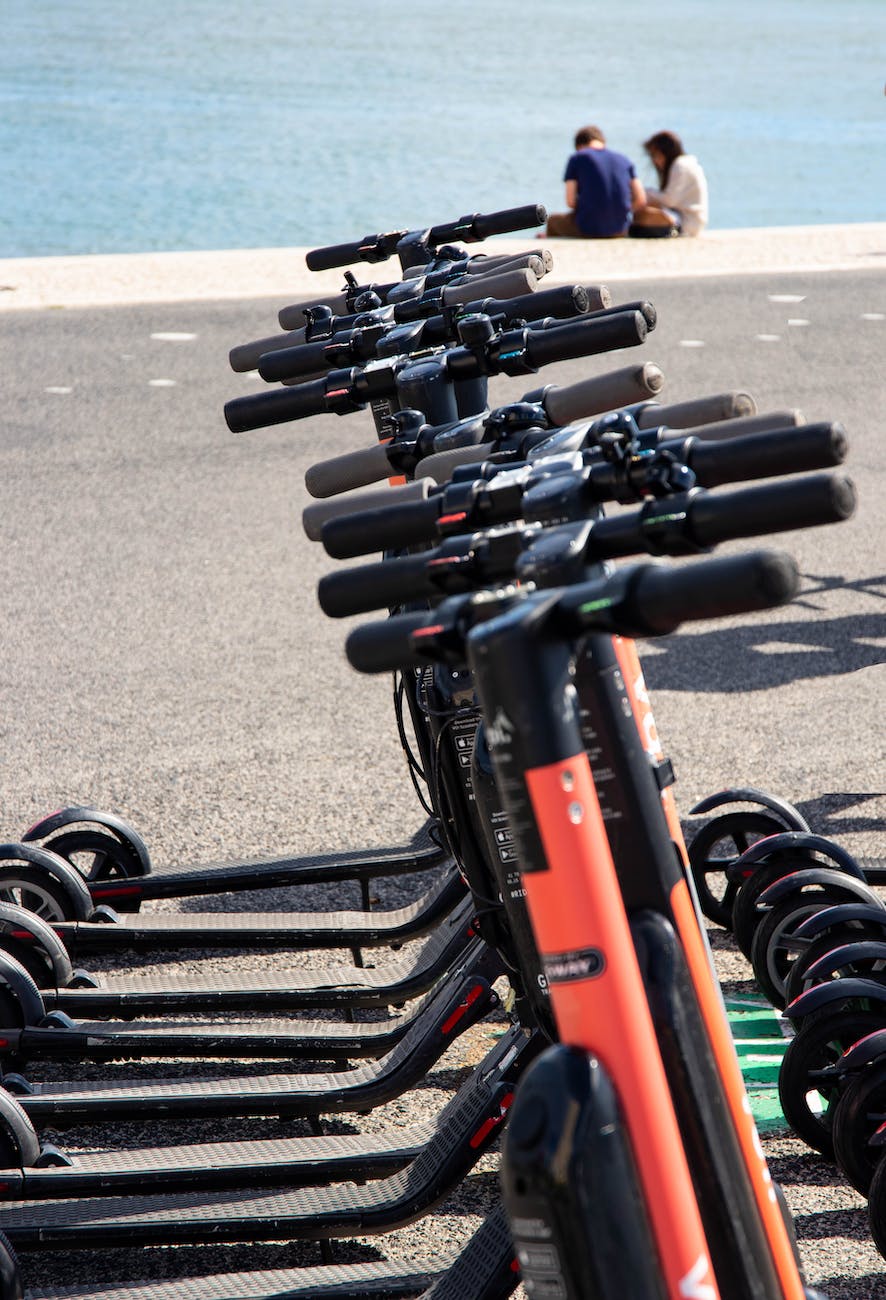 black kick scooters parked near body of water