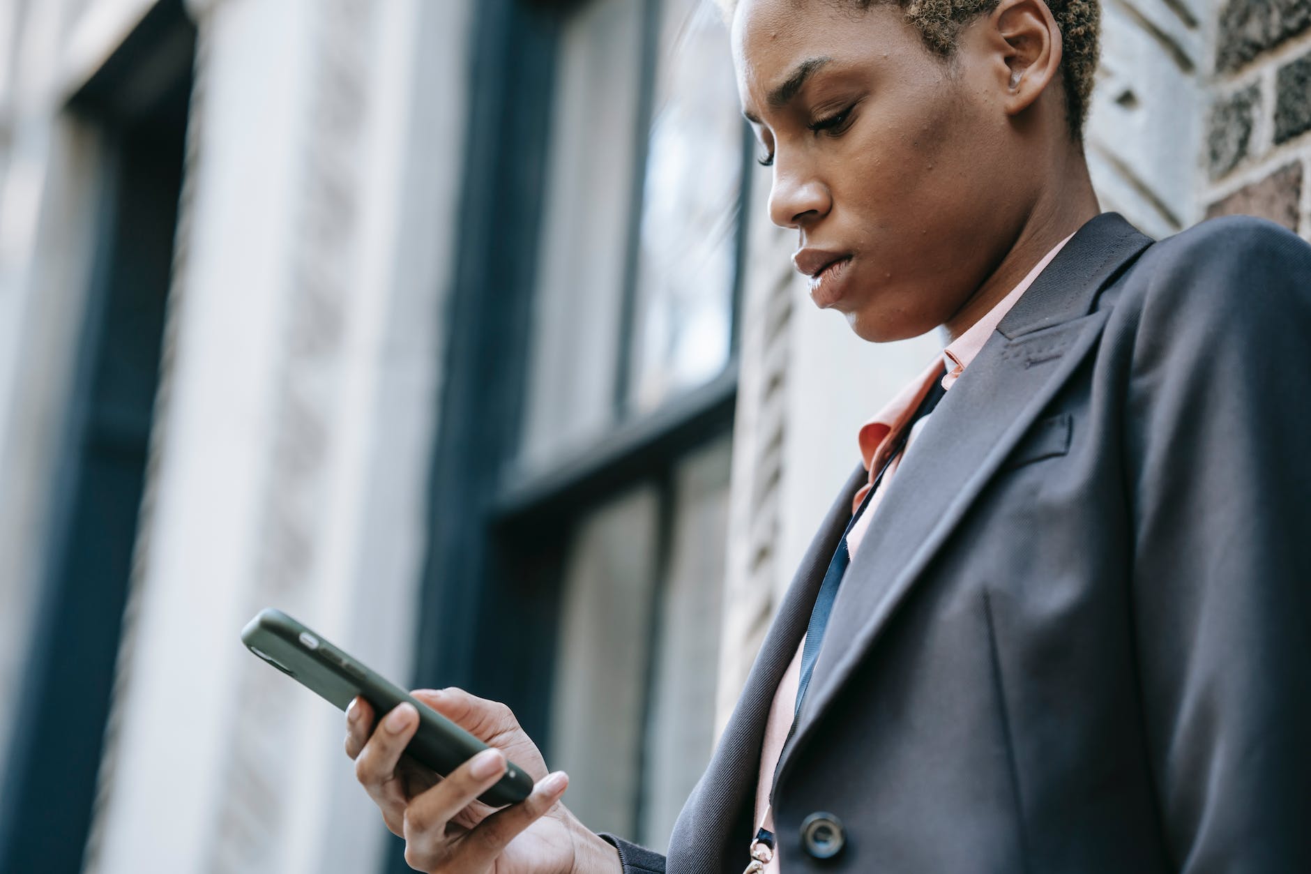 crop concentrated ethnic businesswoman with smartphone