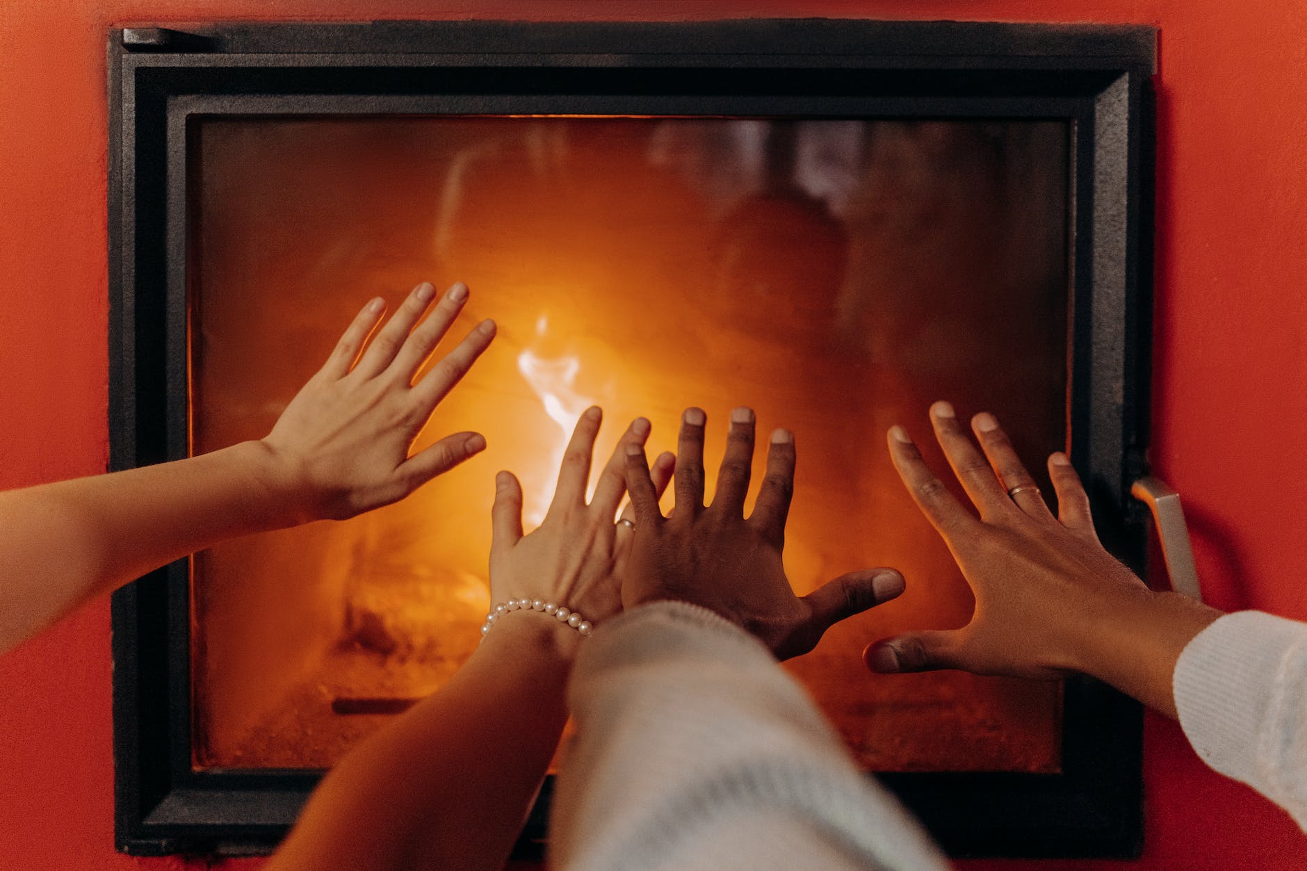 couples hands by fireplace