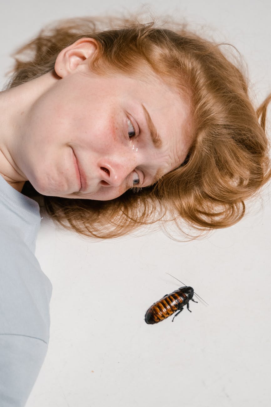 close up photo of a fearful woman lying down while overcoming her fear of cockroaches