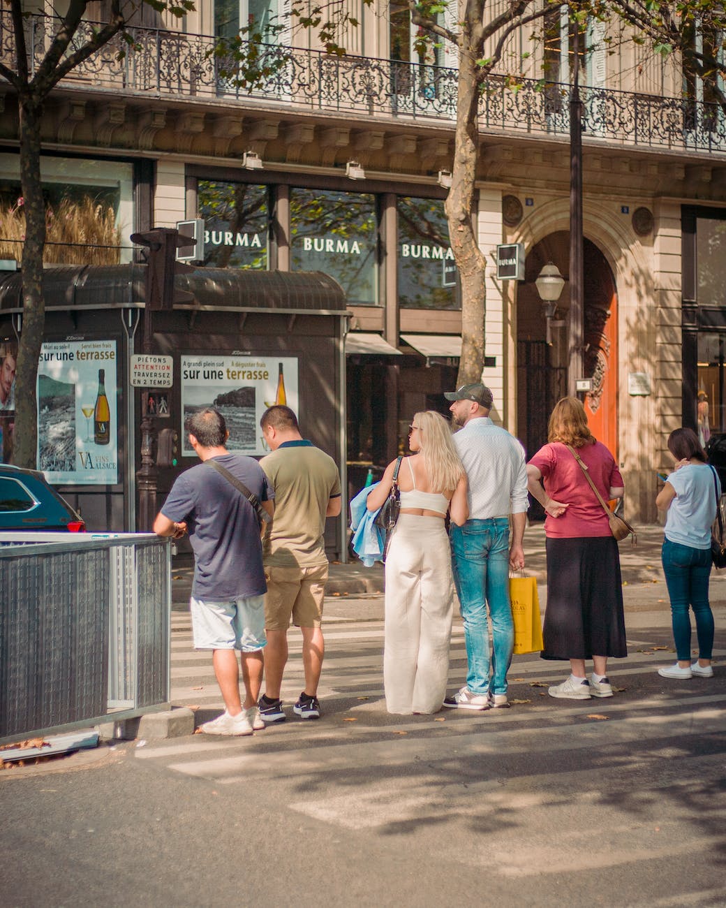 photo of people waiting at a zebra crossing in paris france