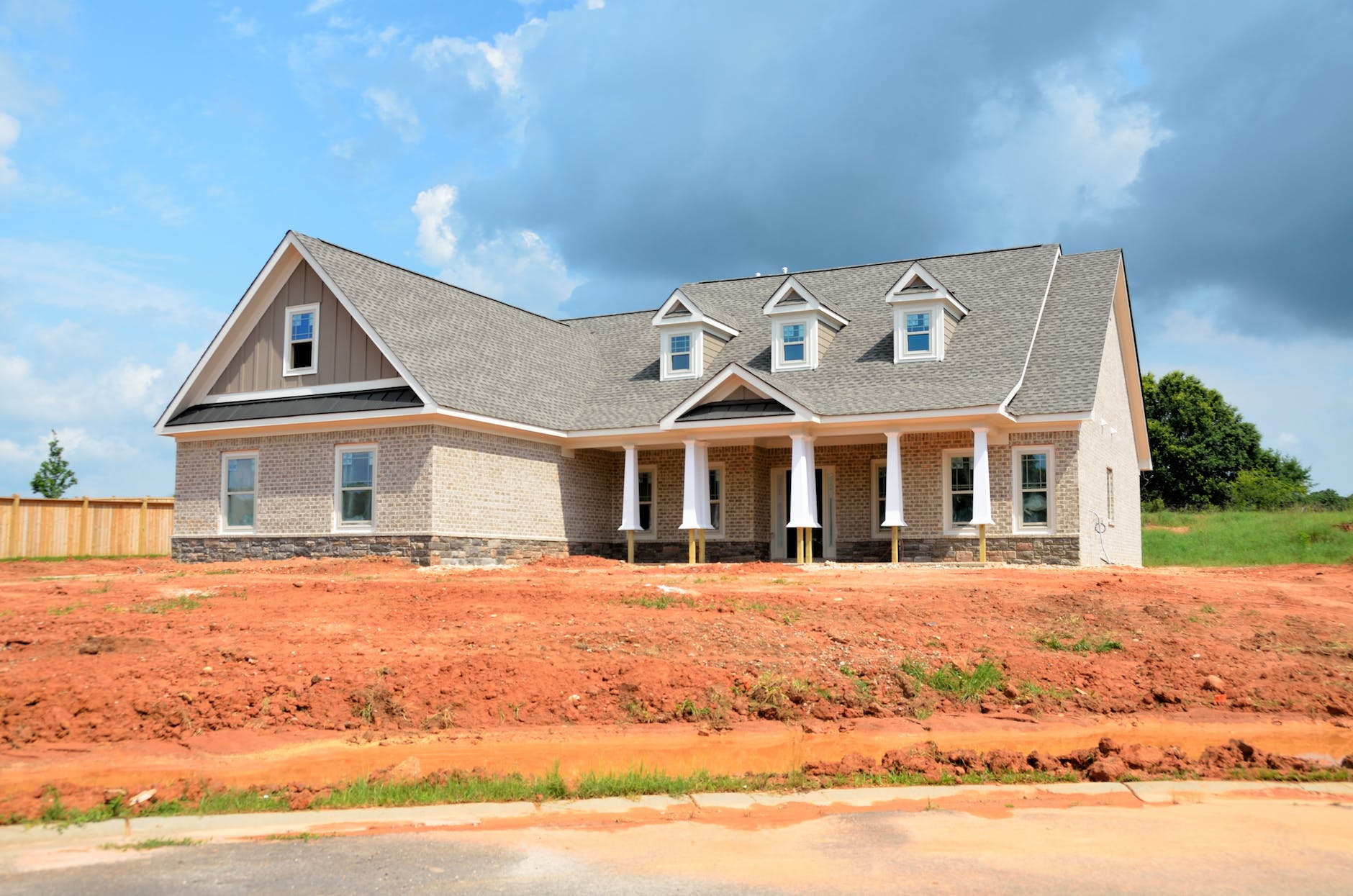 gray bungalow house under blue and white cloudy sky