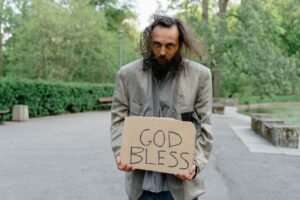 a homeless man holding a sign